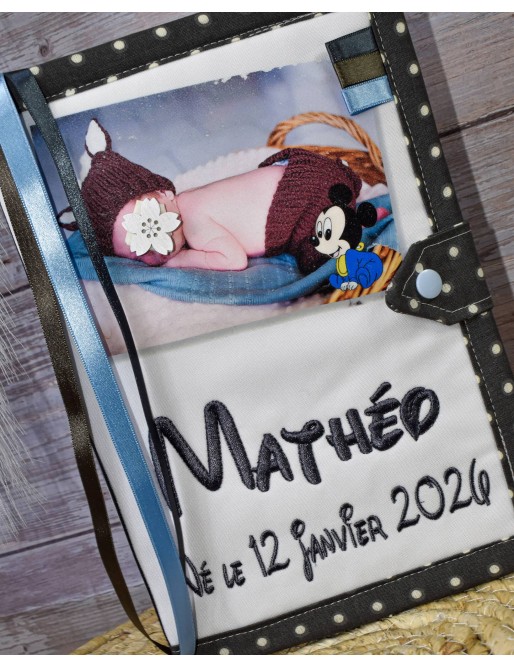 Le protège carnet de santé avec la photo de votre bébé
la photo imprimé et les textes en broderie
