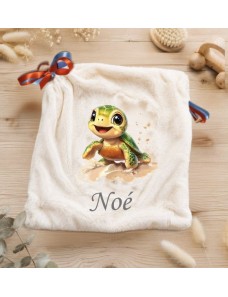 Doudou écru personnalisé Noé avec une tortue verte souriante sur le sable